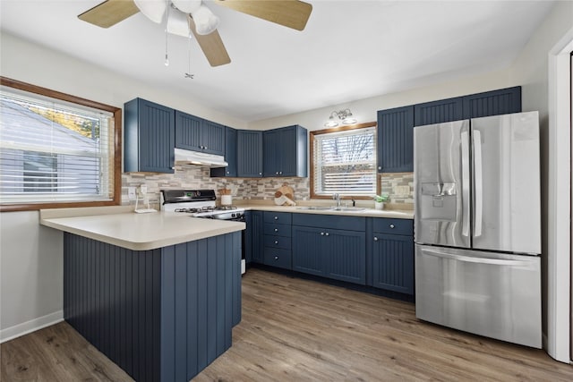 kitchen with blue cabinets, light hardwood / wood-style flooring, stainless steel refrigerator with ice dispenser, and kitchen peninsula