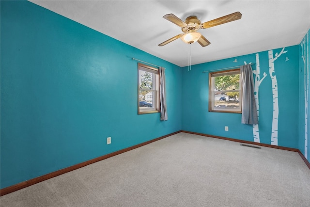 carpeted spare room featuring ceiling fan