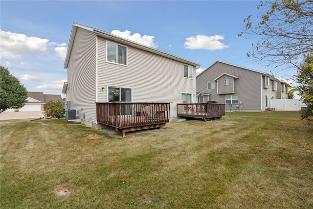 back of house with central air condition unit, a deck, and a lawn