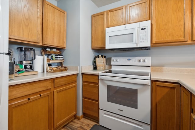 kitchen featuring wood-type flooring and white appliances