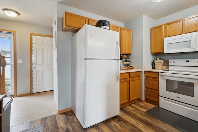 kitchen with dark hardwood / wood-style flooring, a textured ceiling, and white appliances