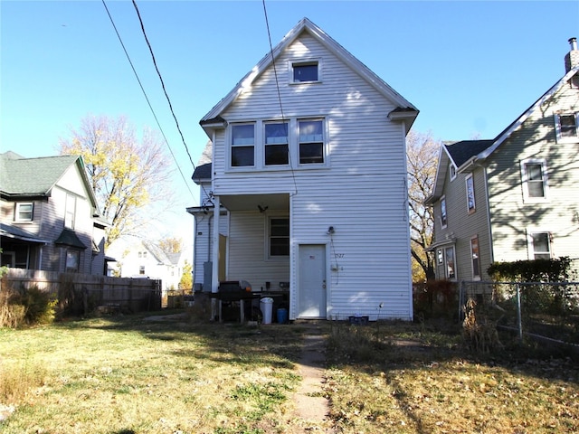 rear view of property featuring a yard