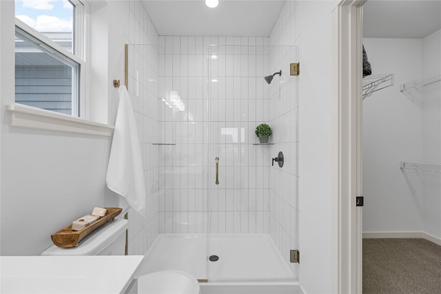 bathroom featuring toilet, a shower with shower door, and vanity