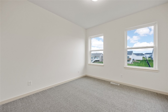 spare room featuring carpet and vaulted ceiling