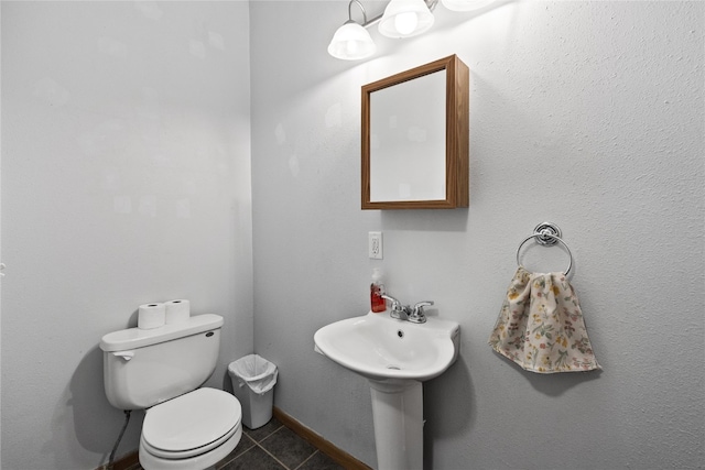 bathroom with toilet and tile patterned flooring