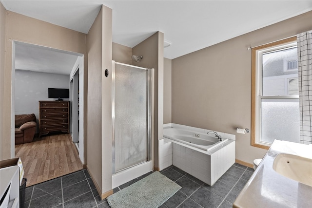 bathroom with a wealth of natural light, separate shower and tub, vanity, and hardwood / wood-style flooring