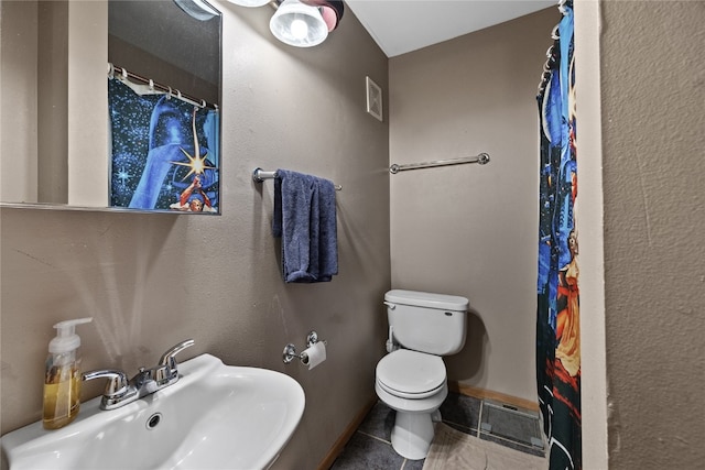 bathroom with sink, curtained shower, toilet, and tile patterned flooring