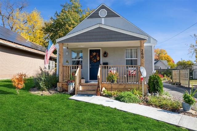 bungalow-style house with covered porch and a front lawn