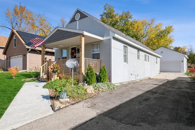 view of front of home featuring an outdoor structure, a garage, and a porch