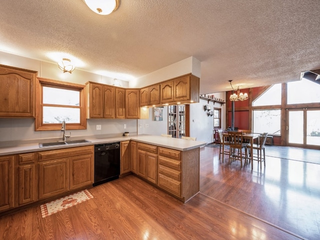 kitchen with sink, a healthy amount of sunlight, dishwasher, and kitchen peninsula