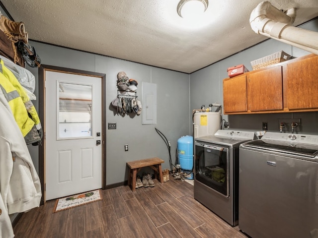 laundry area featuring dark hardwood / wood-style flooring, a textured ceiling, separate washer and dryer, and cabinets