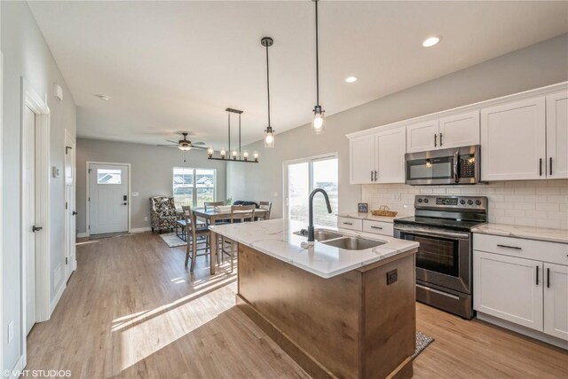 2734 Rookwood Ln, Marion, IA 52302 - kitchen featuring stainless steel appliances, a sink, backsplash, light wood finished floors, and white cabinets