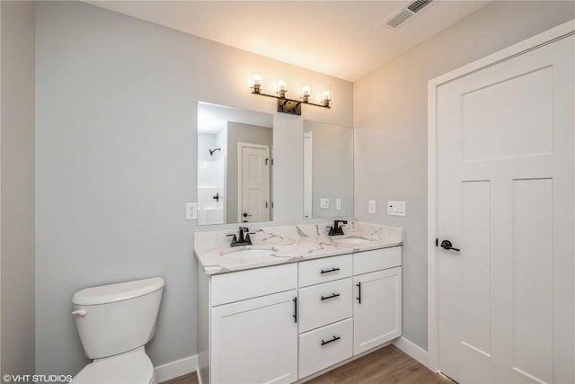 2734 Rookwood Ln, Marion, IA 52302 - bathroom featuring toilet, double vanity, baseboards, and wood finished floors