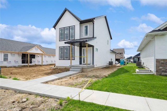 2734 Rookwood Ln, Marion, IA 52302 - view of front of property with central air condition unit, a front lawn, and board and batten siding