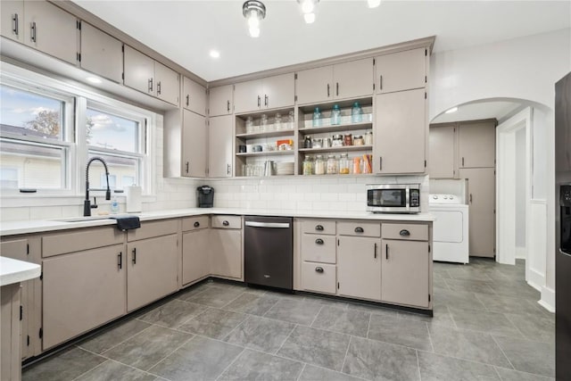 kitchen featuring washer / dryer, appliances with stainless steel finishes, sink, and decorative backsplash