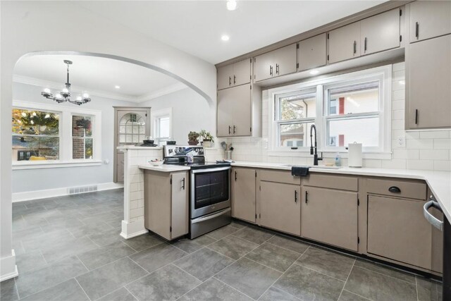 kitchen featuring pendant lighting, a wealth of natural light, stainless steel electric stove, and sink