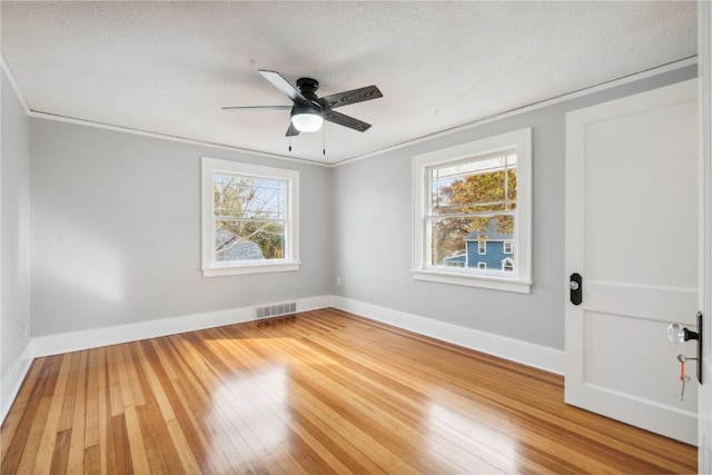 unfurnished room featuring wood-type flooring, plenty of natural light, ceiling fan, and crown molding