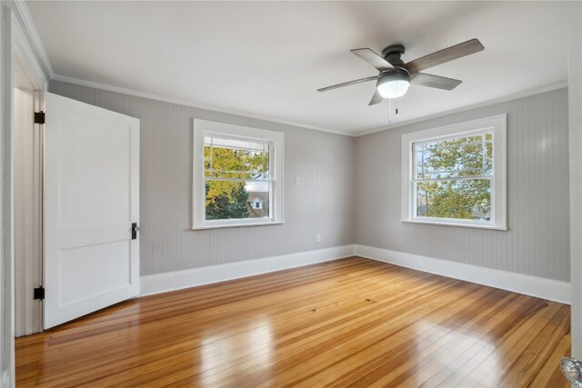 empty room with crown molding, hardwood / wood-style floors, and ceiling fan