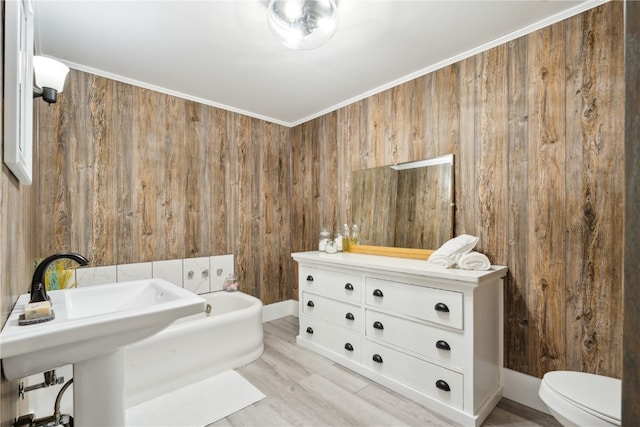 bathroom with crown molding, hardwood / wood-style floors, and toilet