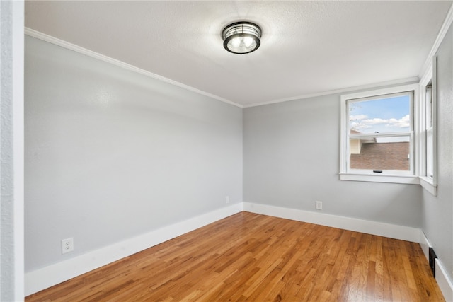 spare room with crown molding and wood-type flooring