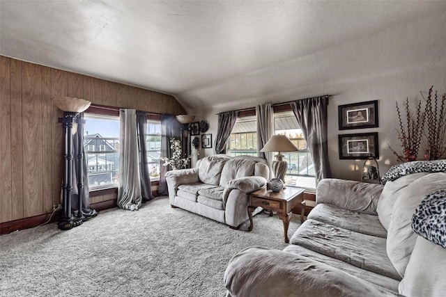 carpeted living room featuring wood walls and vaulted ceiling