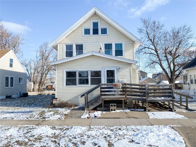 snow covered house featuring a deck