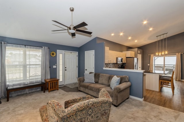 living room with lofted ceiling, light wood-type flooring, and ceiling fan