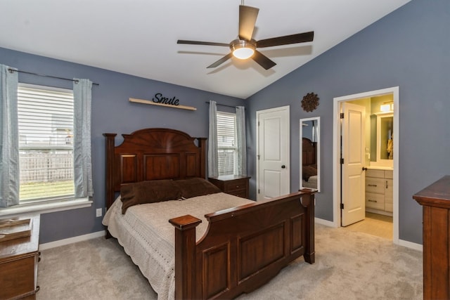 bedroom featuring ceiling fan, light colored carpet, connected bathroom, and vaulted ceiling