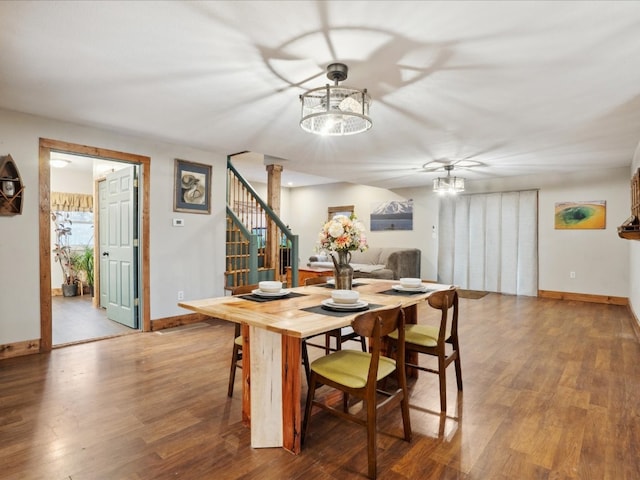 dining room with wood-type flooring and ceiling fan with notable chandelier