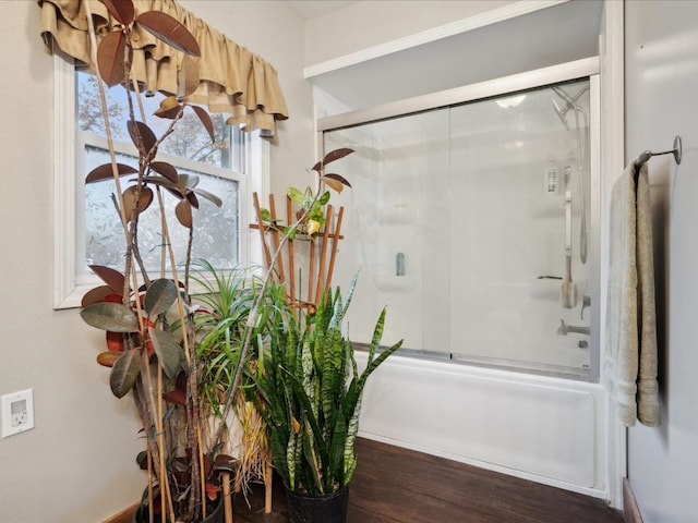 bathroom with hardwood / wood-style floors and enclosed tub / shower combo