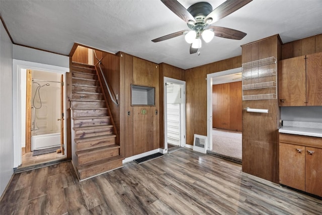 foyer featuring wood walls, hardwood / wood-style floors, and ceiling fan