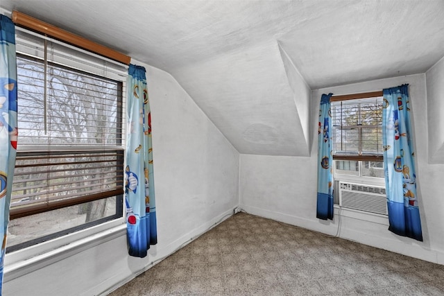 additional living space with light carpet, lofted ceiling, a textured ceiling, and cooling unit