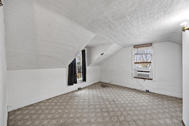 additional living space with cooling unit, a textured ceiling, light colored carpet, and vaulted ceiling