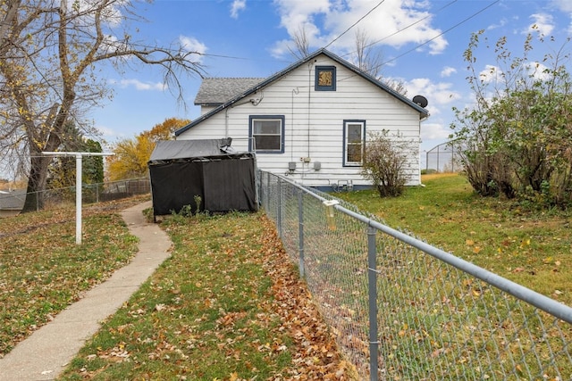 rear view of property featuring a lawn