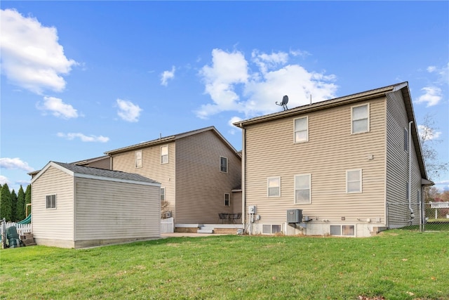 rear view of property with a lawn and central AC unit