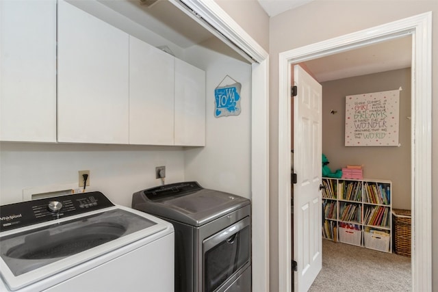 laundry area featuring separate washer and dryer, light colored carpet, and cabinets