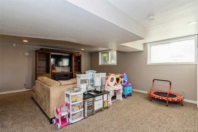 recreation room with carpet and a textured ceiling