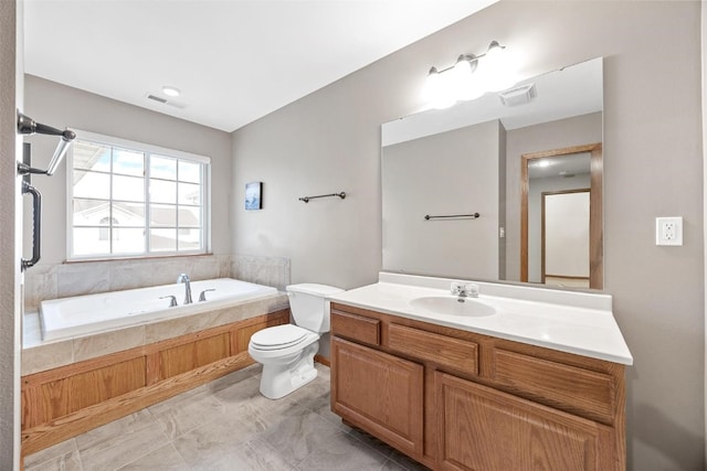 bathroom featuring tiled bath, tile patterned flooring, vanity, and toilet