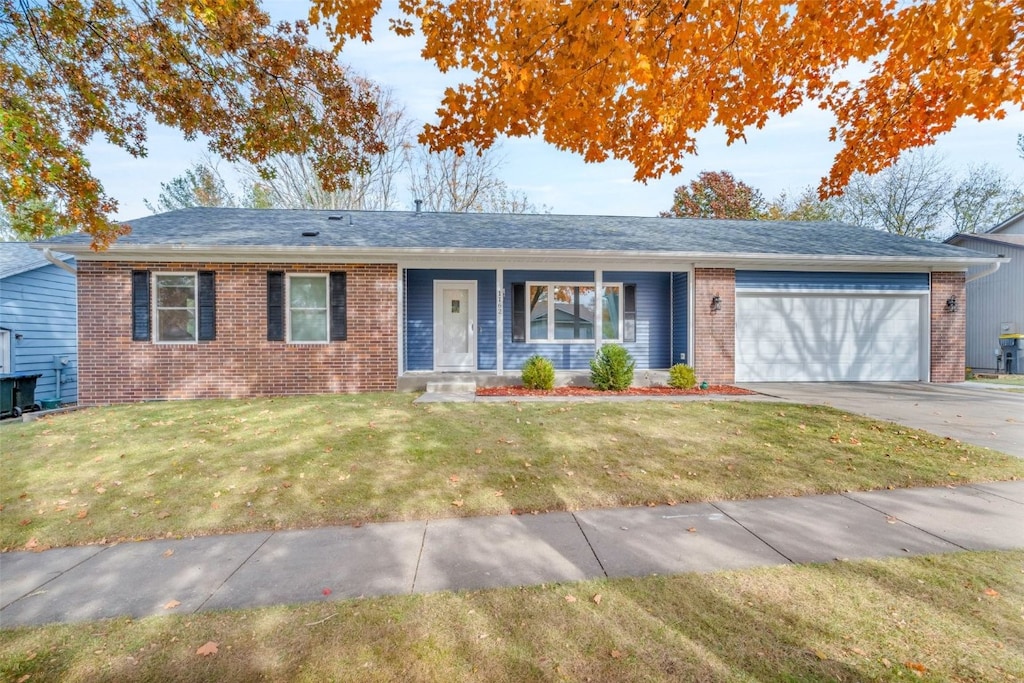 single story home with a garage, a front yard, and a porch