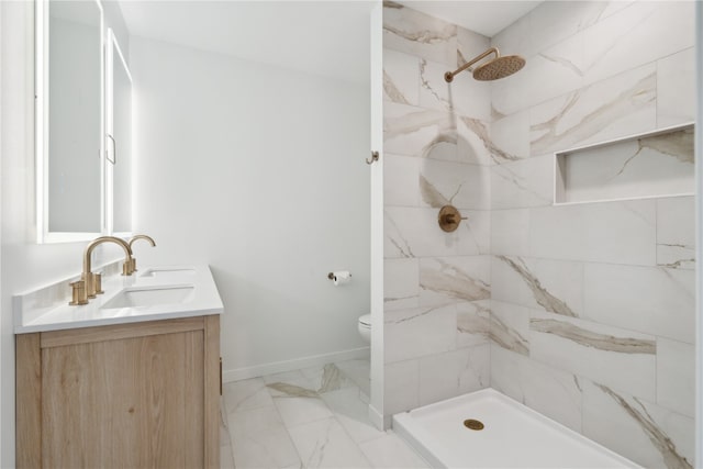 bathroom featuring toilet, vanity, and tiled shower