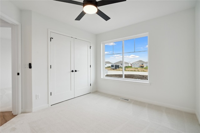 carpeted bedroom featuring ceiling fan and a closet