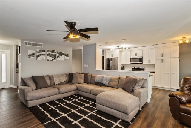 living room featuring dark hardwood / wood-style flooring and ceiling fan