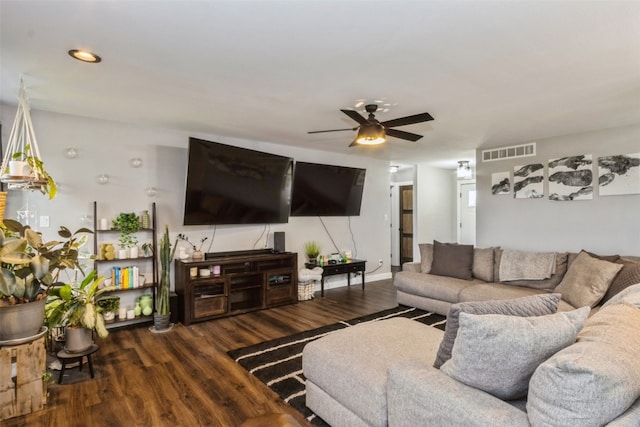 living room featuring dark wood-type flooring and ceiling fan