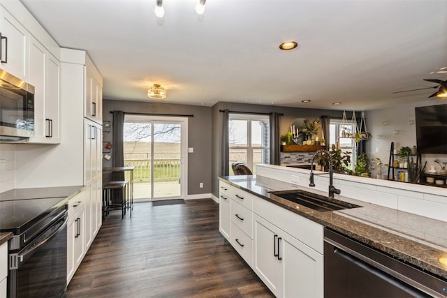 kitchen featuring dark hardwood / wood-style floors, white cabinetry, sink, and appliances with stainless steel finishes