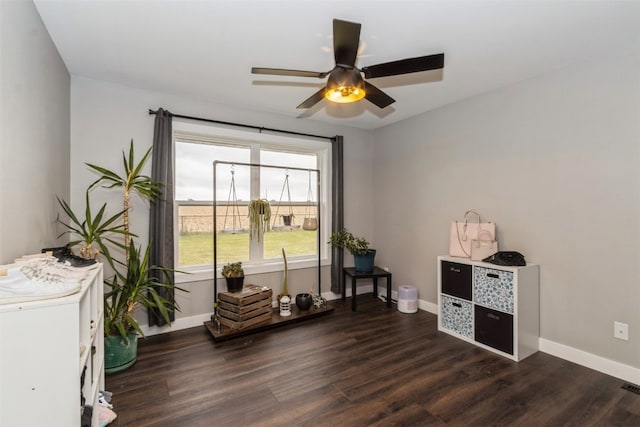 living area featuring ceiling fan and dark hardwood / wood-style floors