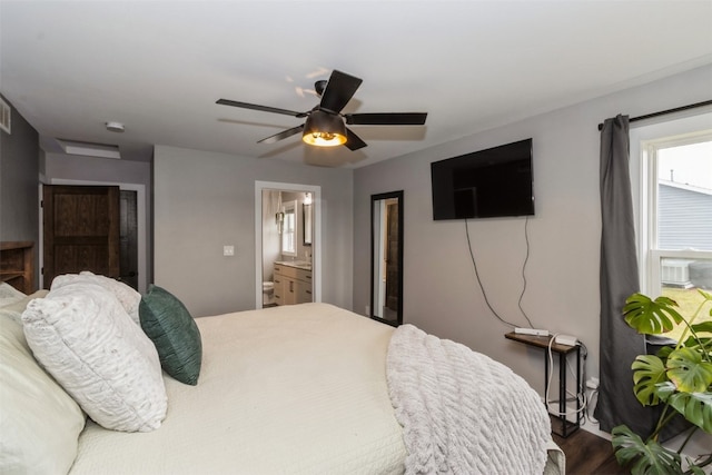 bedroom featuring hardwood / wood-style floors, ceiling fan, and ensuite bath