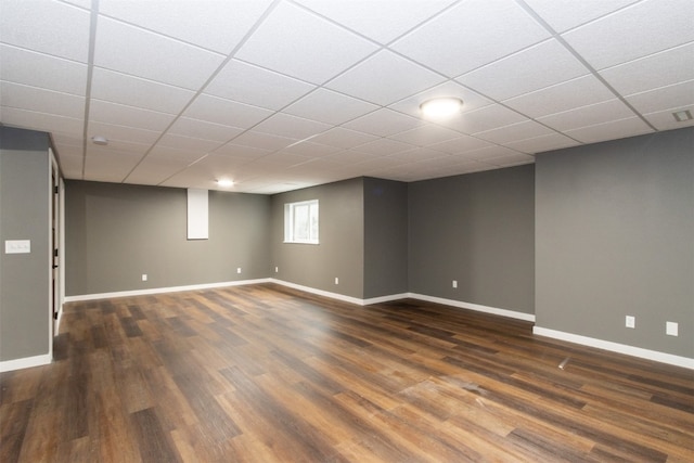 basement featuring dark hardwood / wood-style floors and a drop ceiling