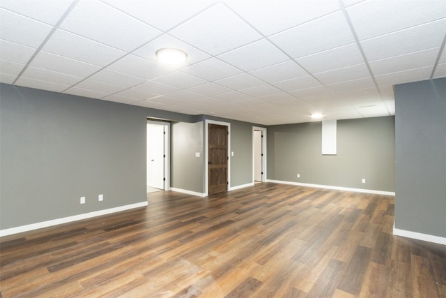 basement featuring a drop ceiling and dark hardwood / wood-style floors