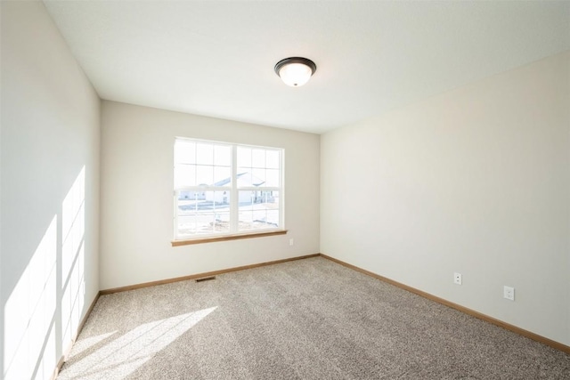 carpeted empty room with visible vents and baseboards