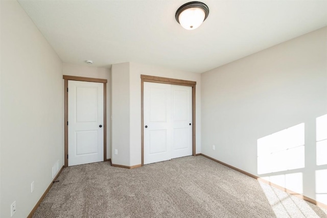 unfurnished bedroom featuring carpet floors, visible vents, baseboards, and a closet